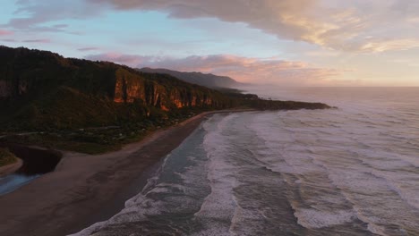 Scenic-aerial-drone-flight-during-beautiful-sunset-over-Pancake-Rocks-at-Punakaiki-with-steep-cliffs-and-ocean-views-on-the-West-Coast-of-South-Island,-New-Zealand-Aotearoa