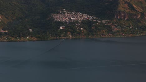 Tilt-up-shot-of-San-Marcos-at-Lake-Atitlan-Guatemala-during-sunrise,-aerial