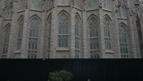 Kippaufnahme-Von-Touristen-Und-Fußgängern,-Die-An-Der-Sagrada-Familia-Vorbeigehen,-Der-Größten-Unvollendeten-Katholischen-Kirche-Der-Welt-Und-Teil-Eines-UNESCO-Weltkulturerbes