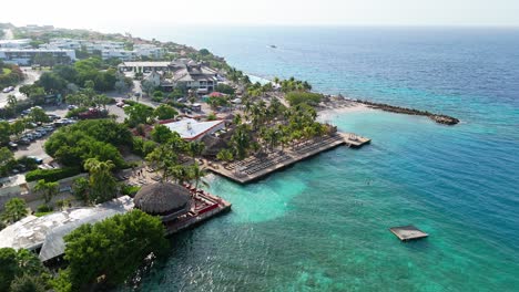 Aerial-parallax-around-Zanzibar-beach-Jan-Thiel-Curacao-with-sun-glistening-on-Caribbean-water
