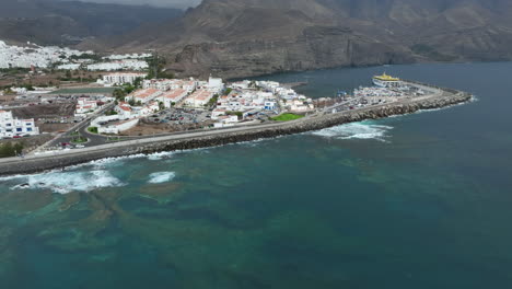 Wonderful-aerial-view-of-the-Agaete-coast-where-you-can-see-houses,-Las-Nieves-port,-and-docked-ferry
