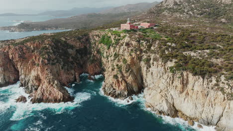 Faro-di-Capo-Spartivento,-Sardinia:-wonderful-aerial-view-in-orbit-of-the-coast-and-the-beautiful-lighthouse