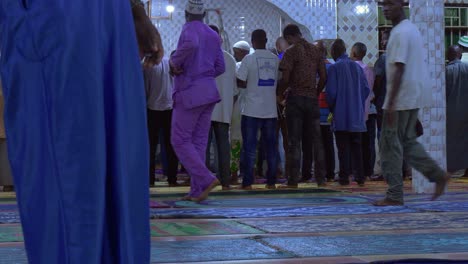 Rückansicht-Von-Menschen,-Die-In-Der-Moschee-Herumlaufen-Und-Darauf-Warten,-Dass-Die-Gebete-Beginnen