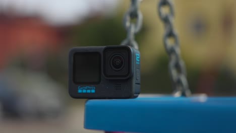 GoPro-Hero-Black-12-Action-Camera-Resting-On-Swing-In-Park-With-Bokeh-Background