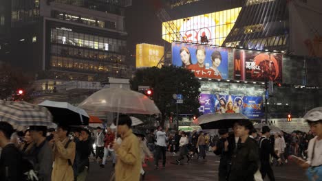 Cruce-De-Shibuya-Y-Vallas-Publicitarias-Por-La-Noche-Durante-La-Lluvia,-Tokio,-Japón