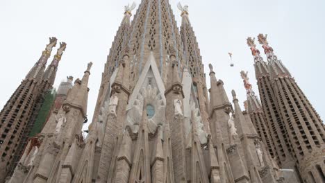 Tilting-down-shot-of-the-Sagrada-Familia,-the-largest-unfinished-Catholic-church-in-the-world-and-part-of-a-UNESCO-World-Heritage-Site
