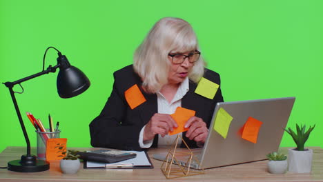 Tired-exhausted-senior-business-woman-office-manager-with-laptop-sticky-notes-sticks-with-many-tasks