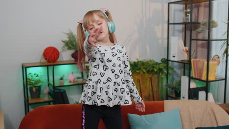 Glückliches-Kind-Mit-Kopfhörern,-Das-Tanzt-Und-Springt,-Während-Es-Allein-Zu-Hause-Musik-Hört