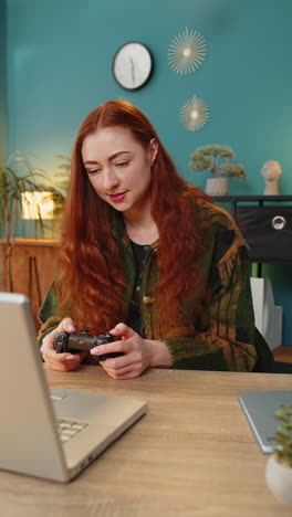 Excited-Caucasian-woman-playing-video-game-on-laptop-computer-spending-leisure-time-at-home-office