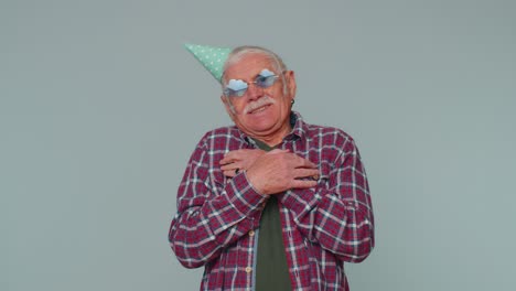 Cheerful-positive-senior-man-in-cone-festive-hat,-dancing,-having-fun,-celebrating-birthday-party
