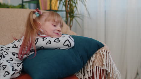 Little-tired-lazy-sleeping-children-girl-lying-asleep-on-sofa-feeling-lack-of-energy-at-home-alone