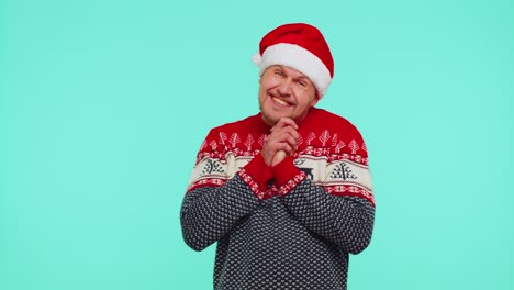Smiling-man-in-Christmas-sweater-makes-heart-gesture-demonstrates-love-sign-expresses-good-feelings