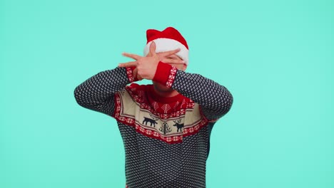 Crazy-man-in-sweater-Santa-Christmas-hat-demonstrating-tongue-out,-fooling-around-making-silly-faces