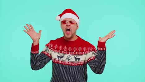 Man-in-Christmas-sweater-listening-music-via-earphones,-dancing-disco-fooling-around-having-fun