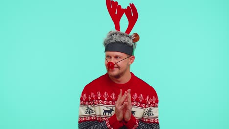Cheerful-man-in-sweater-Santa-Christmas-hat-getting-present-gift-box,-expressing-amazement-happiness