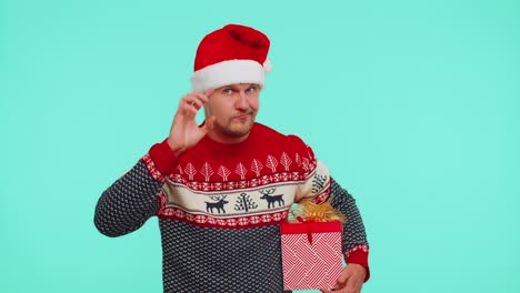 Man-in-Christmas-sweater-pointing-at-camera,-showing-stupid-gesture,-blaming-some-idiot-for-plan