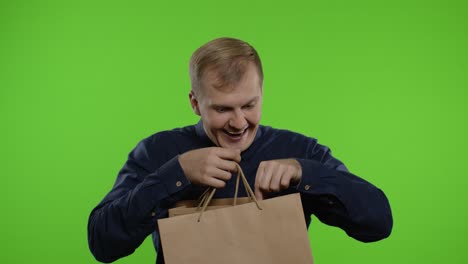 Joyful-man-showing-Black-Friday-inscription-from-shopping-bags,-smiling-satisfied-with-low-prices