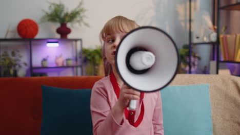 Child-girl-kid-standing-on-sofa-at-home-alone-loudly-shout-in-megaphone-announces-discounts-sale