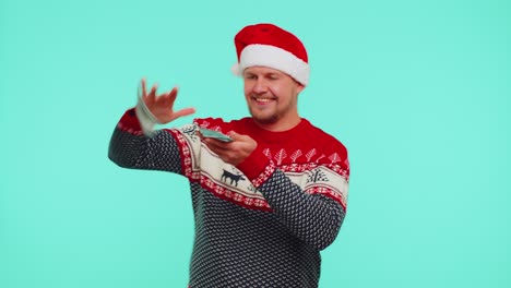 Gewinner-Des-Reichen-Mannes-Im-Weihnachtlichen-Roten-Pullover-Und-Hut,-Der-Zeigt,-Wie-Er-Geld-Verschwendet,-Herumwirft-Und-Einkauft