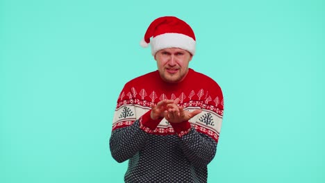 Upset-disappointed-man-in-red-New-Year-sweater-wipes-tears-and-cries-from-despair-not-received-gift