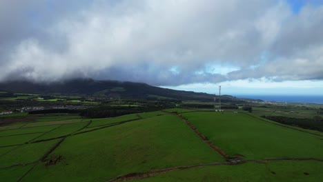 Elevated-aerial-footage-overlooking-lush-farm-fields-at-Serra-do-Cume,-swift-moving-clouds