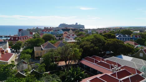 Drone-ascends-over-Otrobanda-Willemstad-Curacao-with-cruise-ship-in-distance-at-port