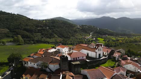 Aerial-orbit-around-castle-town-in-Vinhais,-Braganza,-Portugal-in-lush-green-valley