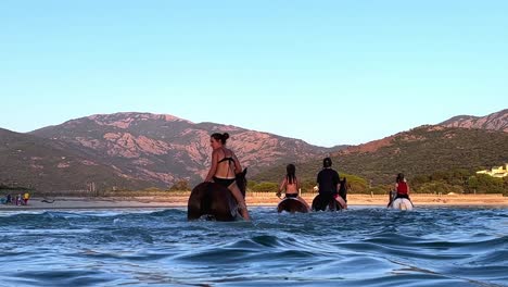 People-riding-horse-in-sea-water-in-summer-season