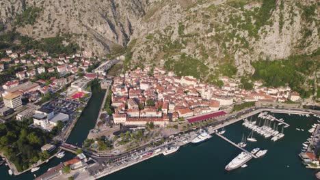 Aerial-establishing-shot-of-Kotor-cityscape-by-Adriatic-sea,-Orbiting-shot