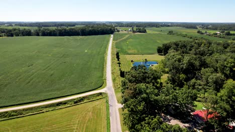 Farm-fields-in-the-midwest-USA-with-car-driving-down-long-straight-road
