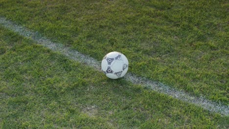 Close-shot-of-football-soccer-player-kicking-ball-on-professional-pitch