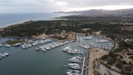 Wide-rotating-drone-footage-of-the-marina-near-San-Jose-del-Cabo-in-Los-Cabos-Mexico-with-boats-docked-in-harbor