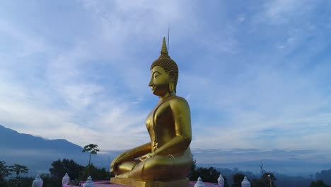 Huge-Gold-Budda-Crane-Shot-Aerial-Drone-Statue-Towering-Mountians-Laos-Thailand-Cinematic