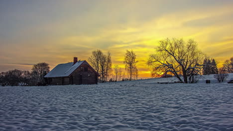 Timelapse-of-a-sunrise-in-a-snowy-rural-landscape-with-a-log-cabin