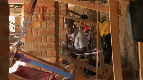 Poor-black-men-from-Ghana-happily-weaving-Kente-textile-between-bricks