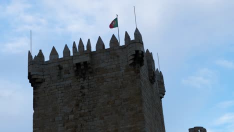 Red-and-green-flag-waves-strong-and-proud-in-wind-on-tower-at-Chaves-Vila-Real-Portugal
