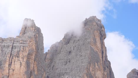 Tre-Cime-di-Lavaredo-mountain-peaks-cut-through-fog-and-clouds-in-Dolomites,-Italy