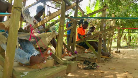 Trabajadores-Africanos-De-La-Comunidad-Local-Tejiendo-Manualmente-Tejidos-Tradicionales-Kente