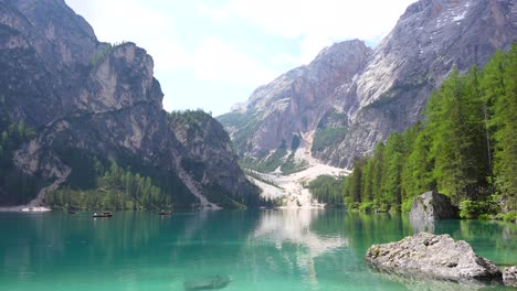 Wooden-boats-on-Lago-di-Braies-at-base-of-Croda-del-becco-slopes,-Dolomites