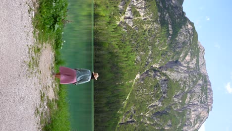 Frau-Im-Rosa-Rock-überblickt-Vor-Ihrer-Abreise-Die-Küste-Des-Lago-Di-Landro,-Dolomiti