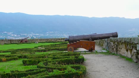 Old-fashioned-cannon-on-wooden-mounting-wheels-on-top-of-battlement-parapet-on-castle-overlooking-Chaves-Vila-Real-Portugal