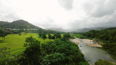 Aerial-establishing-shot-of-a-small-river-running-alongside-a-forest-in-Puerto-Rico