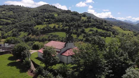 Luftpanoramalandschaft,-Romanische-Kirche-San-Vicente-Serapio-Asturien-Spanien-Riesiges-Grün,-Berge-Und-Klare-Skyline