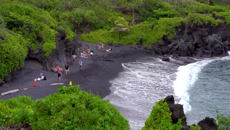 View-of-Black-Sand-Beach-in-Waianapanapa-State-Park-along-the-Road-to-Hana-in-East-Maui,-Hawaii,-a-popular-tourist-destination-along-the-Road-to-Hana