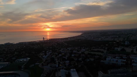 Lissabon-Flüstert-Seine-Küstengeschichten-Bei-Sonnenuntergang,-Während-Goldene-Strahlen-Die-Häuser-Am-Meer,-Das-Denkmal-Der-Entdeckungen-Und-Segelboote-Erhellen-Und-Eine-Ruhige-Symphonie-Der-Küstenträume-Inszenieren