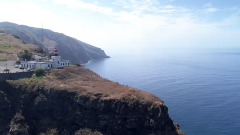 Madeira-Ponto-da-Pargo-Lighthouse-aerial-fly-over-revealing-cliffs-and-coastal-edge