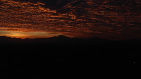 Ein-Dramatischer-Sonnenaufgang,-Der-Unter-Einem-Wolkenverhangenen-Himmel-Goldene-Farbtöne-über-Die-Silhouette-Der-Vulkane-In-Mexiko-Stadt-Wirft