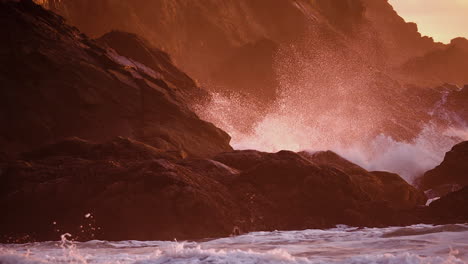 Stormy-Waves-Hitting-Rugged-Shore-Mountains-During-Sunset