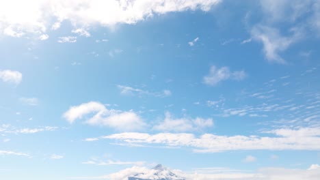 Blick-Auf-Den-Blauen-Himmel-Mit-Wolken-Und-Der-Schwenk-Nach-Unten-Zeigt-Den-Vulkan-Osorno-Neben-Dem-Llanquihue-See-In-Der-Ferne
