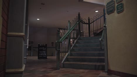 Escaleras-Verdes-En-Un-Edificio-De-Plaza-Con-Un-Cartel-Ahora-Abierto.